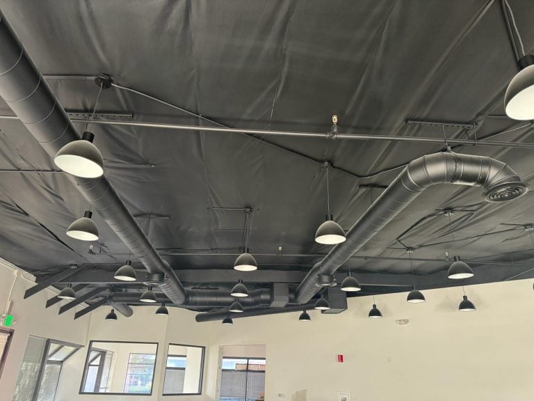Exposed spiral ductwork installed in a commercial space ceiling.