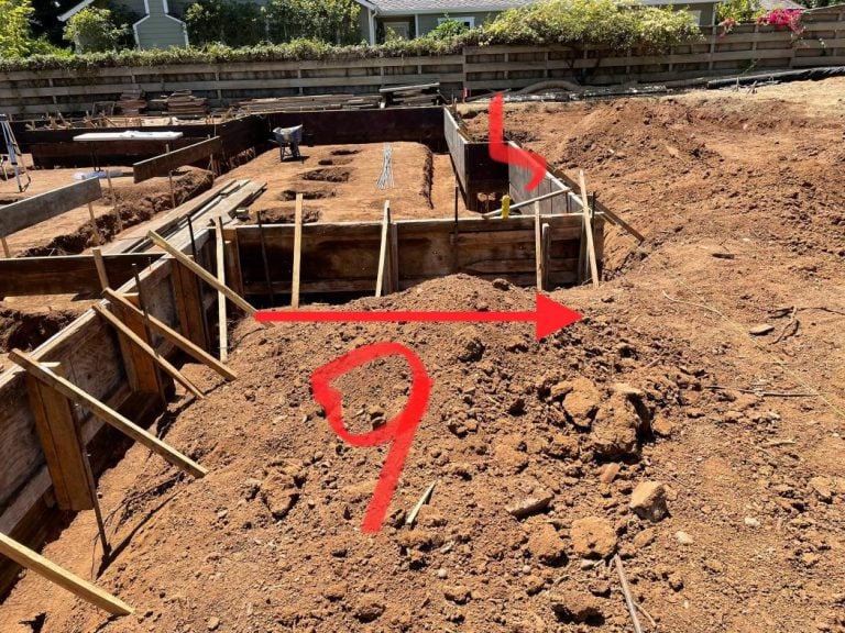 Excavated foundation and footings at a residential construction site.