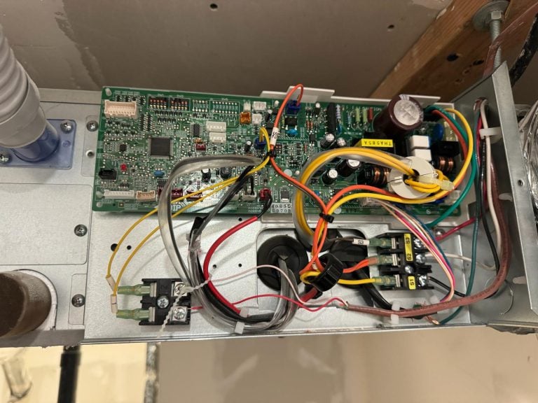 HVAC technician repairing the control board of a heating and cooling system.